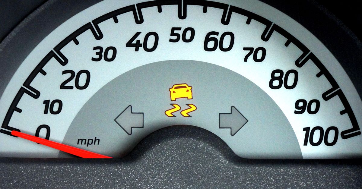 Close-up of a car speedometer displaying a warning indicator. Ideal for automotive themes.