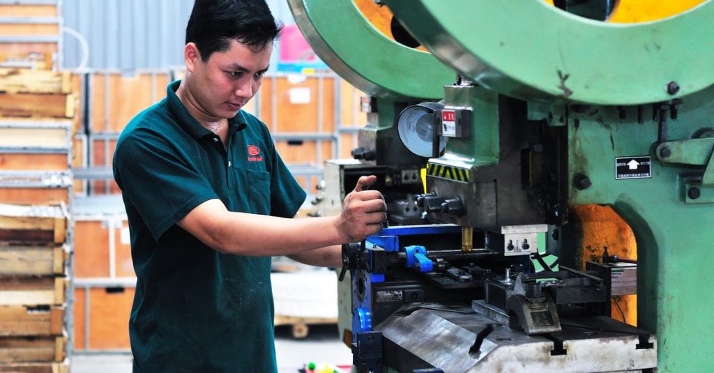 Người vận hành theo dõi máy móc trong môi trường nhà máy sản xuất