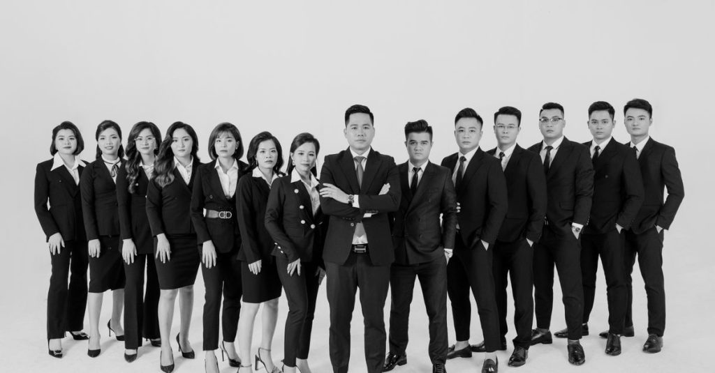 Chân dung đen trắng của một nhóm nhân sự đa dạng trong bối cảnh chuyên nghiệp.