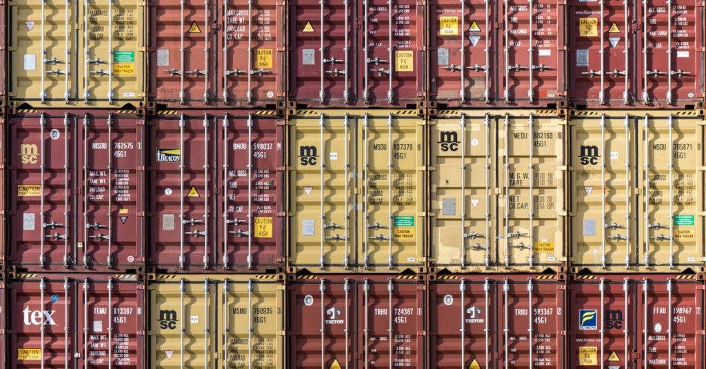 Rows of stacked shipping containers at Hamburg port. Industrial and international trade imagery.