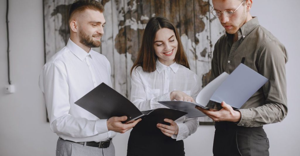Nhóm chuyên viên cùng xem và trao đổi về tài liệu trong môi trường văn phòng chuyên nghiệp.