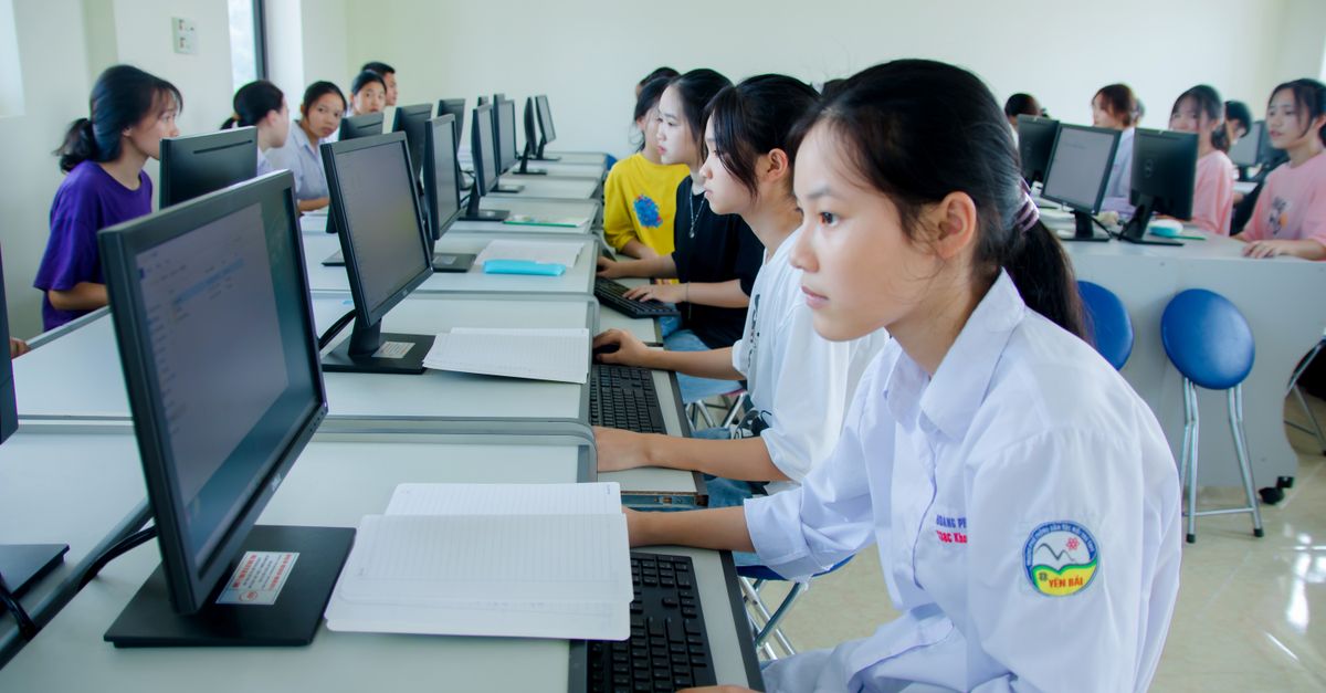 Students engaged in study at a computer lab, focused on technology and teamwork.