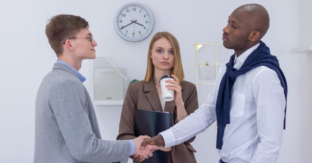 Hai chuyên gia trong bối cảnh chuyên nghiệp bắt tay, thể hiện sự hợp tác quốc tế.