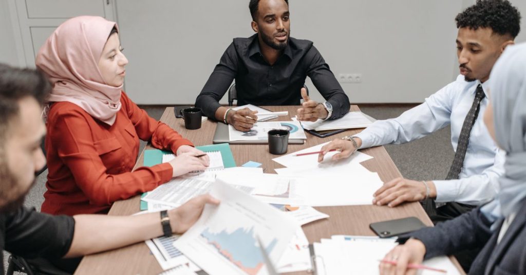 Nhóm nhân sự quốc tế trao đổi tài liệu trong không gian làm việc chuyên nghiệp.